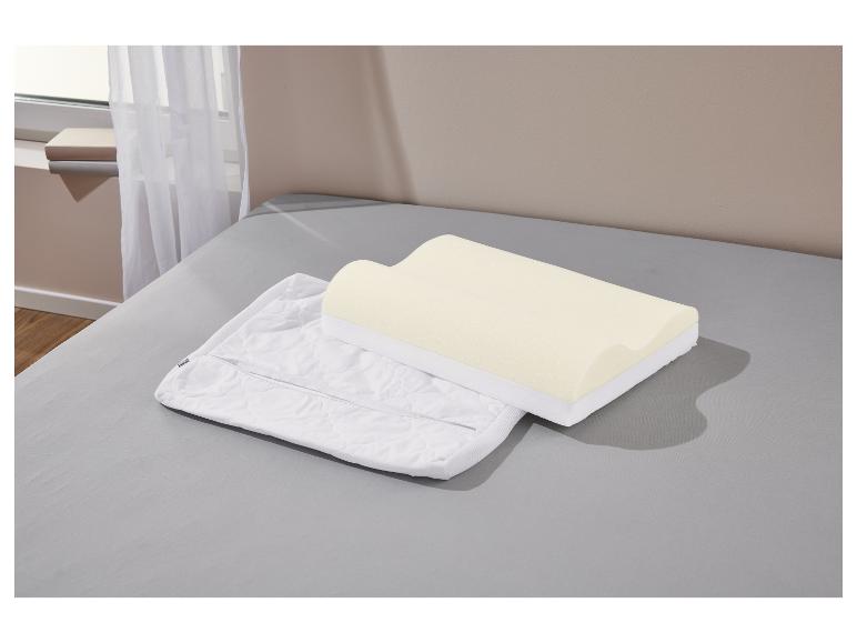 Een traagschuimkussen en zijn kussensloop liggen op een bed.