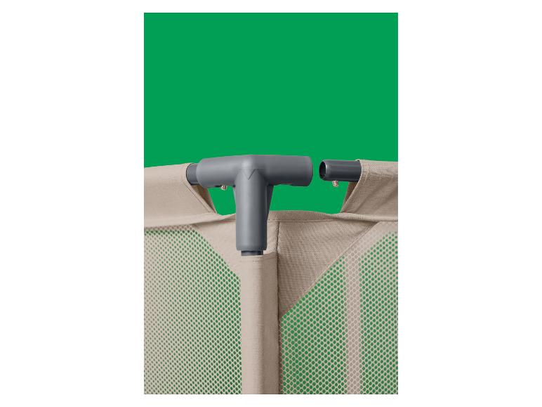 Close-up van een beige wasmand met een grijze plastic connector op een groene achtergrond.