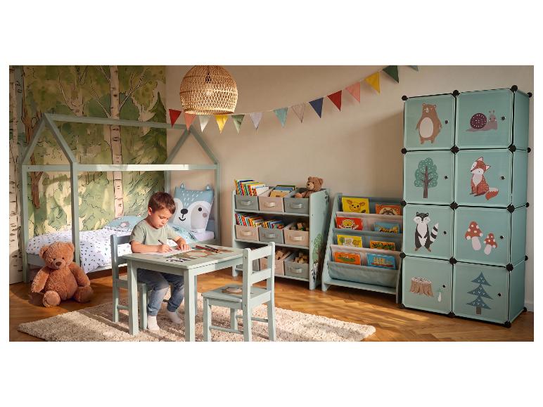 Kinderkamer met houten bed, tafel en stoelen, boekenplanken en opbergkubussen met bosmotieven.