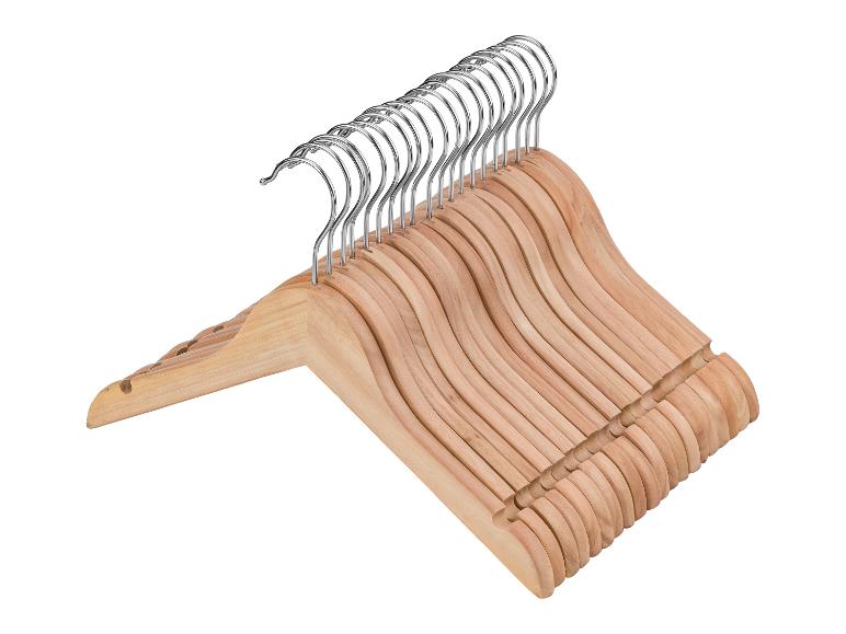Stapel houten kleerhangers met metalen haken, op een witte achtergrond.