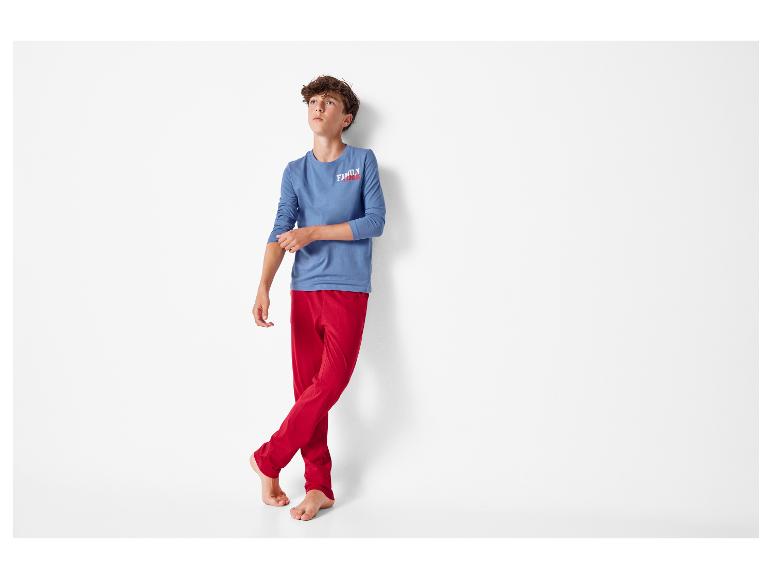 Jongen in blauw shirt met lange mouwen met 'FAMILY TIME' tekst en rode broek.