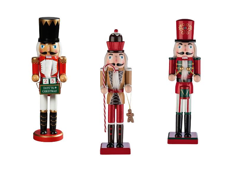 Drie houten notenkrakers, één met een aftelkalender, één met een zuurstok en peperkoekmannetje, en de laatste met een trommel.