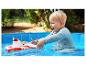 Blond kind speelt met een rood-witte brandweerboot in een blauw zwembad.