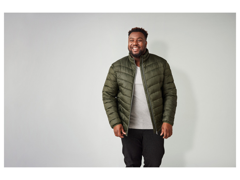 Man in een groene winterjas met een grijze t-shirt.