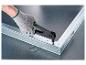 Gehandschoende hand gebruikt een popnageltang om een metalen profiel te bevestigen.