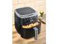 Zwart-zilveren heteluchtfriteuse met frietjes, op een houten aanrecht.