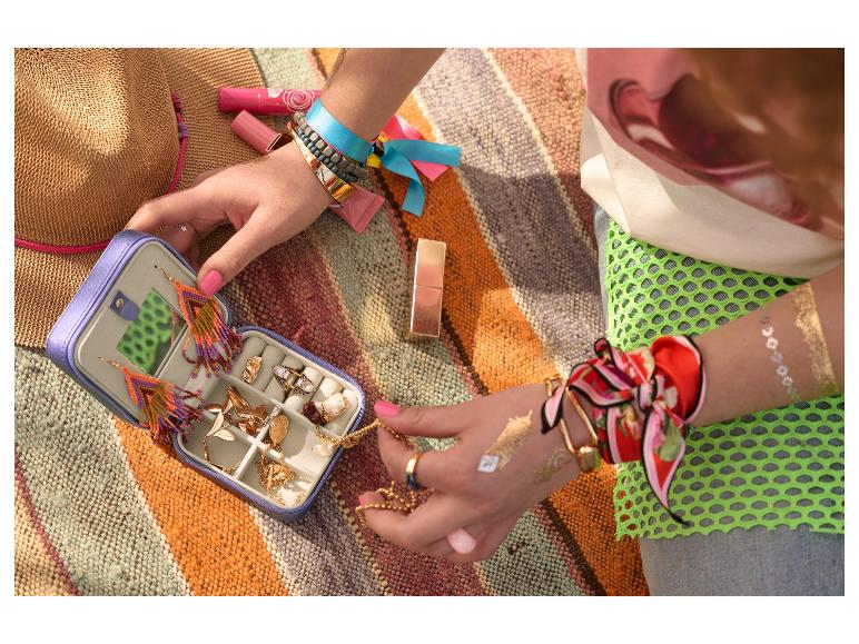 Sieraden, waaronder oorbellen en een ketting, in een sieradendoos.