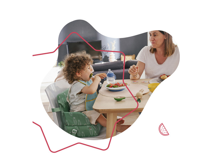 Een kind eet in een Stokke Tripp Trapp kinderstoel met een volwassene.