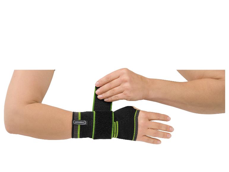 Een man past een Sensipast polsbandage aan.