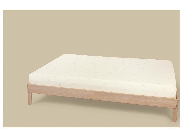 Licht houten bed met matras met vlindermotief op een beige achtergrond