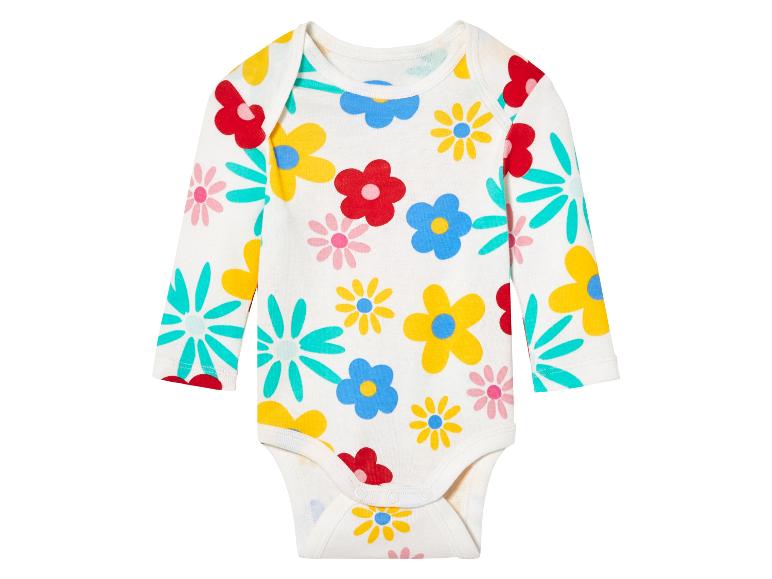 Een babypakje met lange mouwen met een bloemenprint.