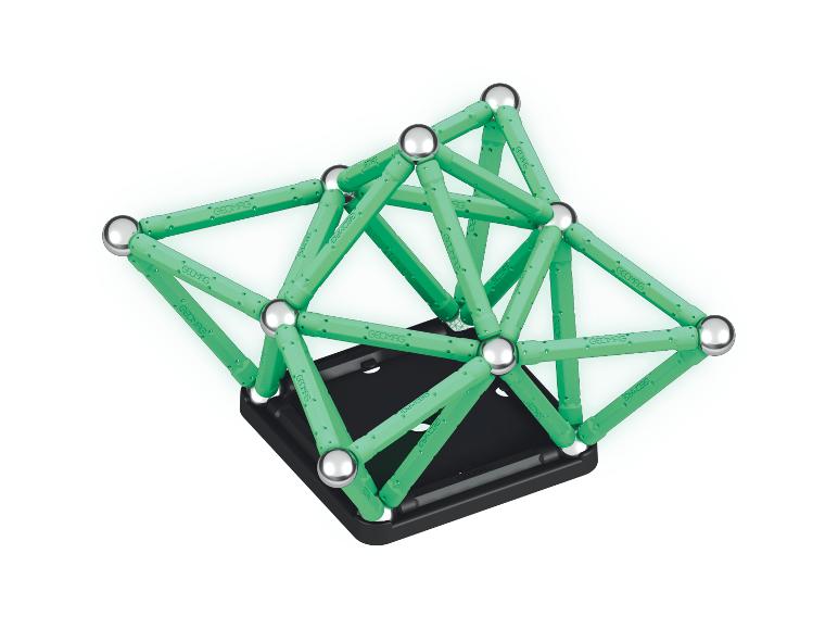 Groene magnetische staafjes en metalen ballen die een constructie vormen op een zwarte basis.