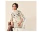 Vrouw in beige gebreide jurk met fair isle patroon, zittend op een stoel.