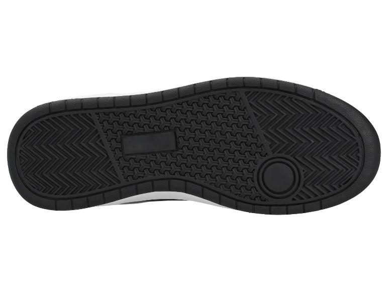 Zwarte zool van een sportschoen met grip patroon en rechthoekig logo.
