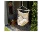 Hangstoel op een terras met patroontegels en planten.