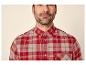 Man in een rood en beige geruit overhemd met knopen.