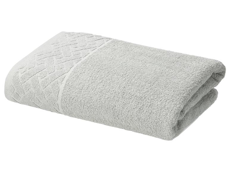 Gevouwen grijze katoenen handdoek met een decoratief patroon