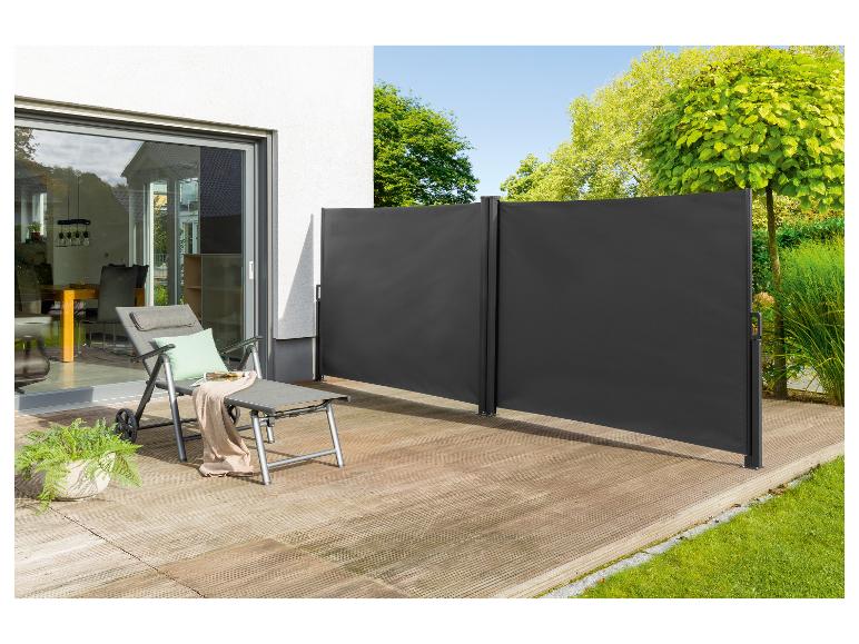 Donkergrijze tuinparasols en ligstoel op een houten terras.