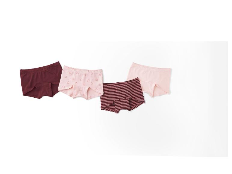 Vier paar meisjesonderbroeken in verschillende kleuren en patronen.
