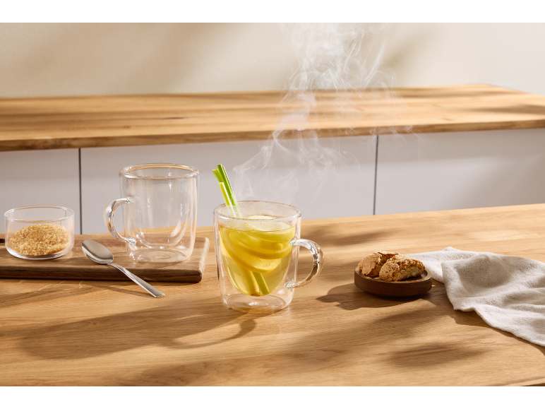 Dampende hete citroenthee, bruine suiker en koekjes op een houten tafel.