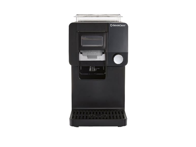 Zwart koffiezetapparaat met dispenser en lekbak.