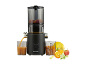 Zwarte slowjuicer met fruit en sap in een glas.