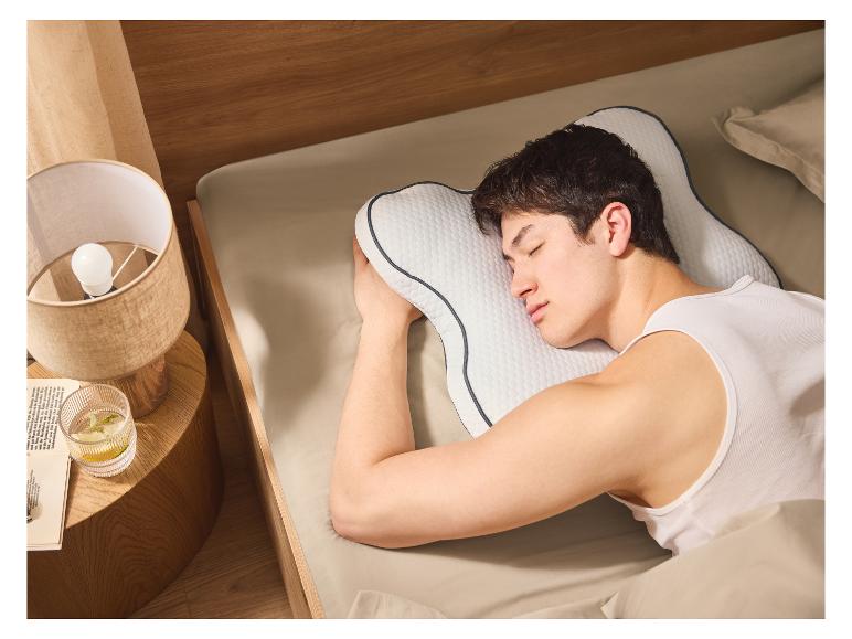 Een man slaapt rustig op een ergonomisch kussen.