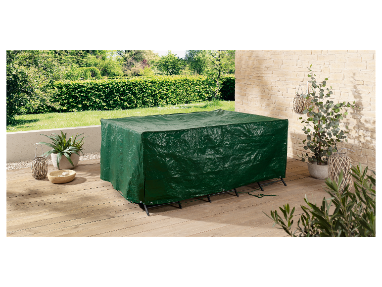 Een donkergroen meubelhoes beschermt een buiten tafel.