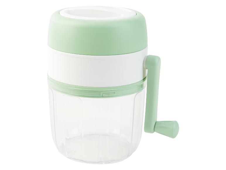 Een lichtgroene handmatige groentesnijder met een transparante container.