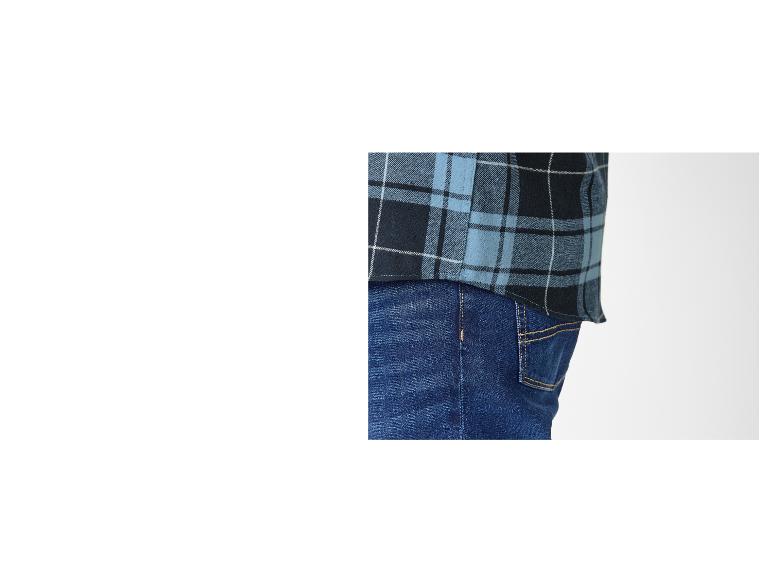 Close-up van een persoon die een blauw en zwart geruit overhemd en jeans draagt.