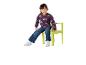 Lachend kind in paarse regenboogtrui en jeans zittend op een groene stoel.