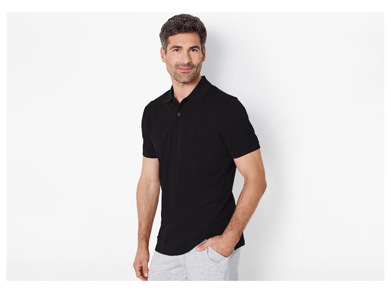 Man in zwart poloshirt en grijze joggingbroek.
