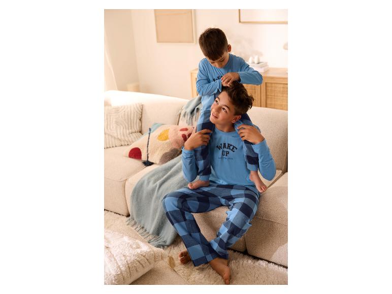 Twee jongens in blauw geruite pyjama's, de een zit op de schouders van de ander.