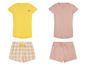 Twee sets pyjama's, één met gele shirts en geruite shorts, één met shirts met bananenprint en shorts met bananenprint.