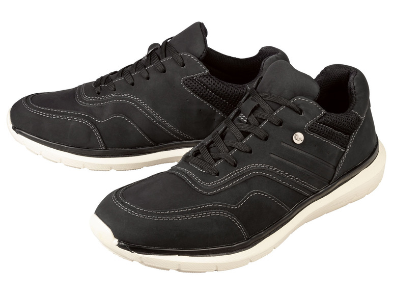 Twee paar zwarte sneakers met witte zolen.