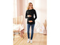 Een zwangere vrouw draagt een zwarte longsleeve en blauwe jeans.