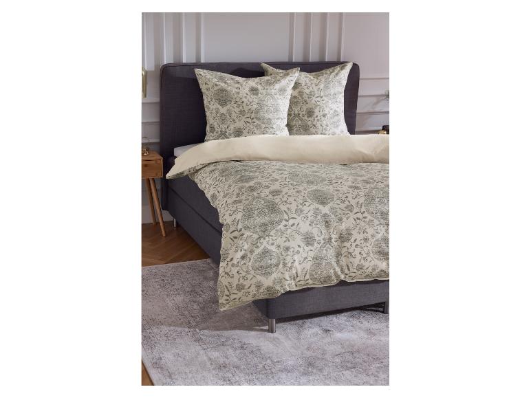 Tweepersoonsbed met beddengoed met patroon en een houten nachtkastje.