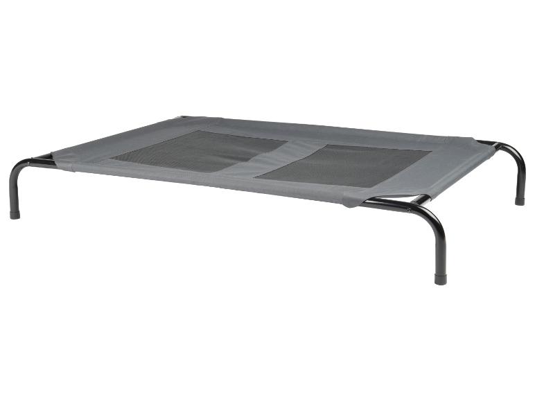 Verhoogd hondenbed met metalen frame en grijze stof.