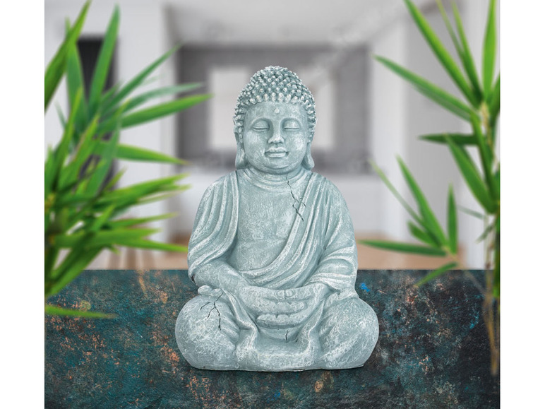 Een grijs Boeddhabeeld in meditatiehouding.
