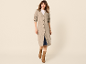 Vrouw in lang beige vest met knopen, wit T-shirt, spijkerrok en bruine laarzen.