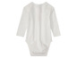 Een wit babypakje met lange mouwen.
