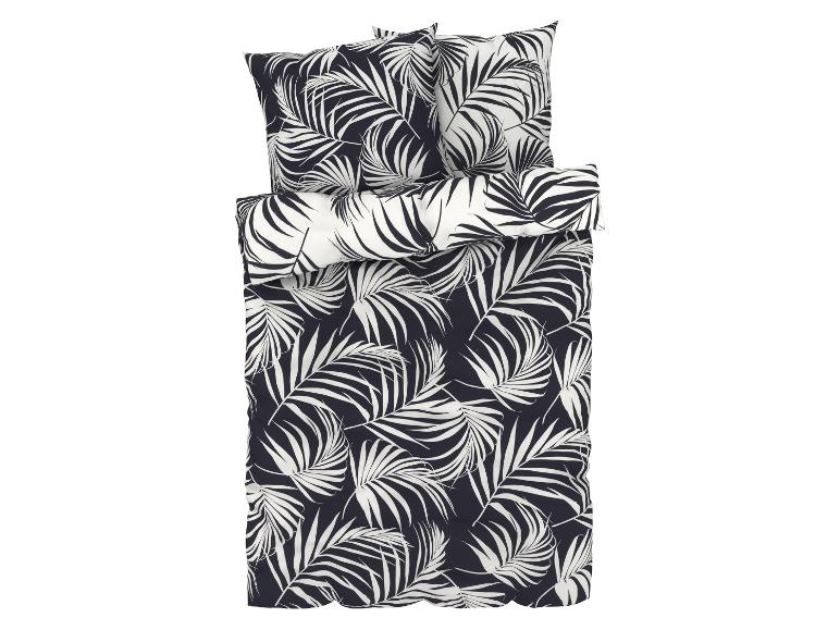 Een dekbedovertrek met kussenslopen in een zwart-witte palmbladerenprint.