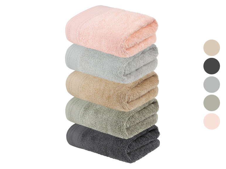 Een stapel badhanddoeken in roze, grijs, beige, groen en grijs.