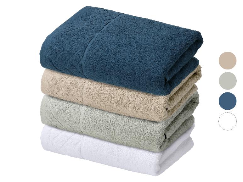 Stapel van vier handdoeken in blauw, beige, groen en wit.