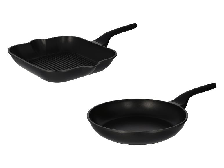 Twee zwarte pannen, een grillpan en een koekenpan, op een witte achtergrond.