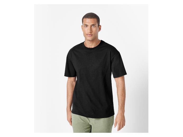 Man draagt een zwart t-shirt en een lichtgroene short.