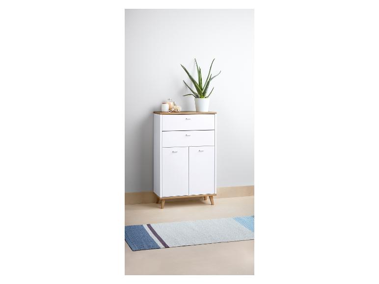 Een witte kast met twee laden en twee deuren, op een blauwe loper.