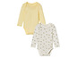 Twee baby-onesies, een gele en een met bijenprint.