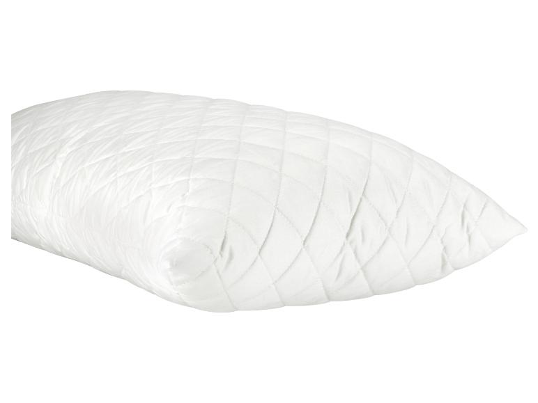 Een wit kussen met een quiltpatroon.