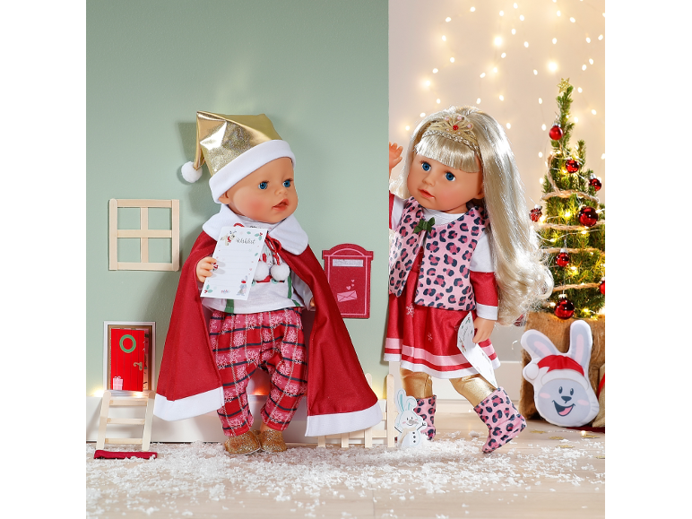 Twee kerstpoppen in feestelijke kleding in een speelse winterse omgeving.